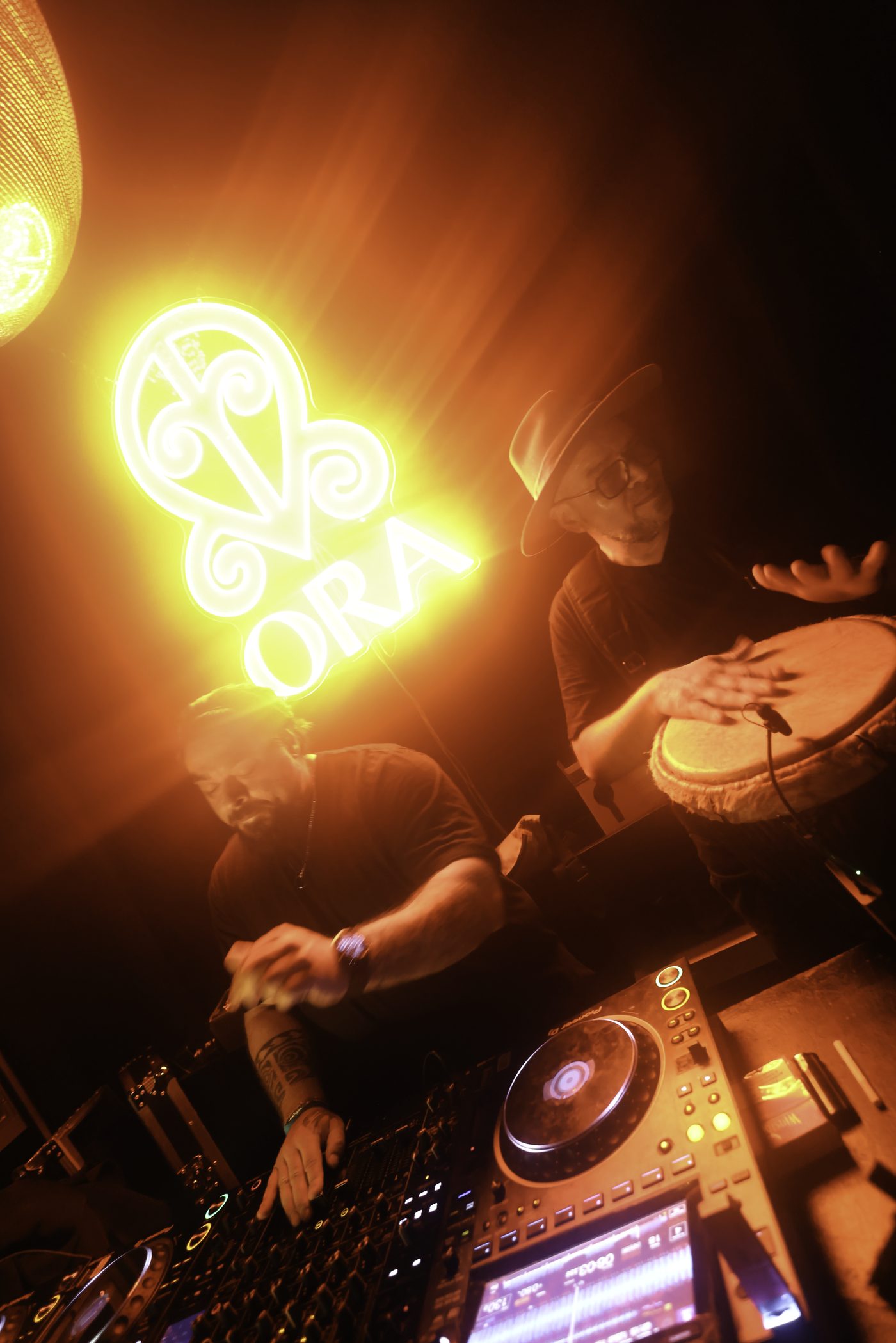 Master M playing djembé next to James Deron at the decks